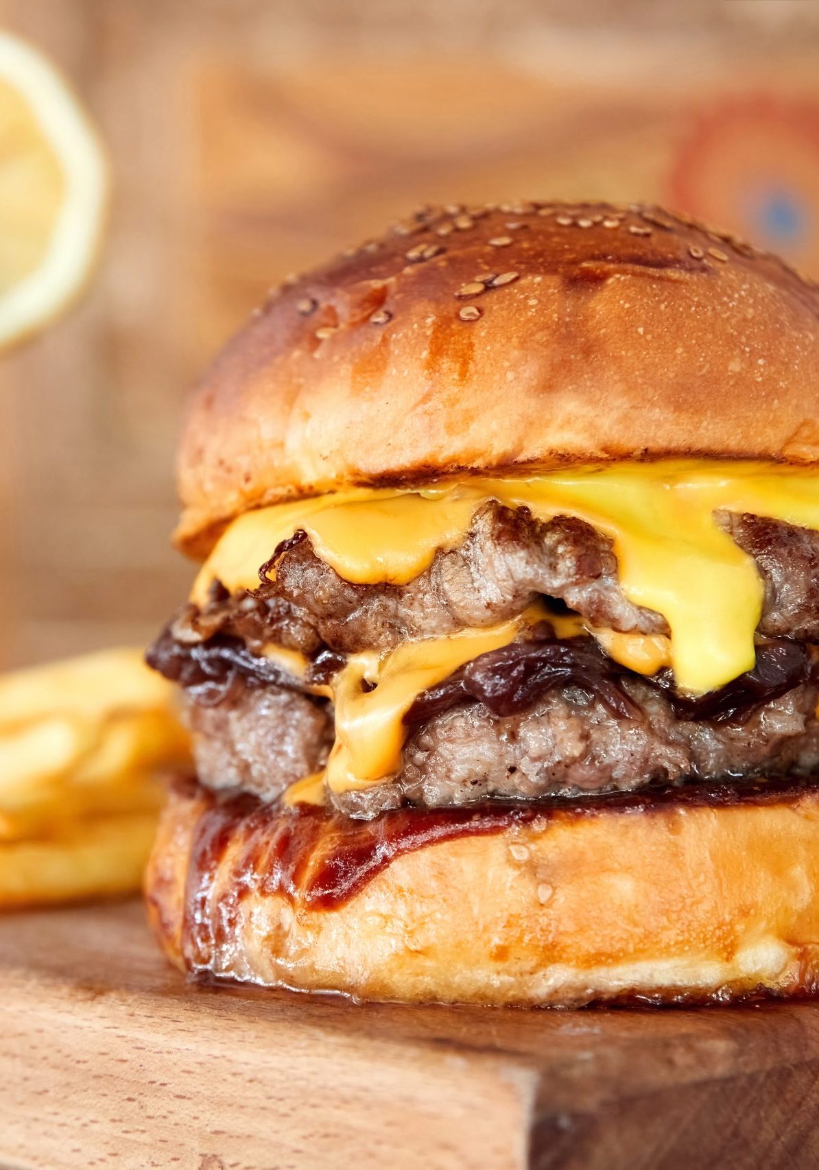 Delicious homemade cheeseburger or hamburger on wooden tray with coke and fires. Close up natural light.